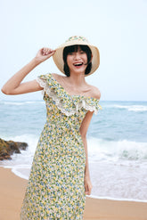 A woman wearing a yellow and green floral dress